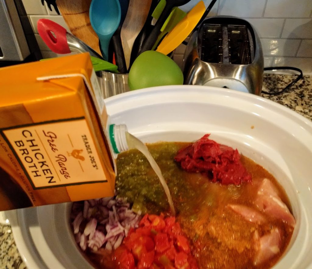 chicken broth being poured into slow cooker