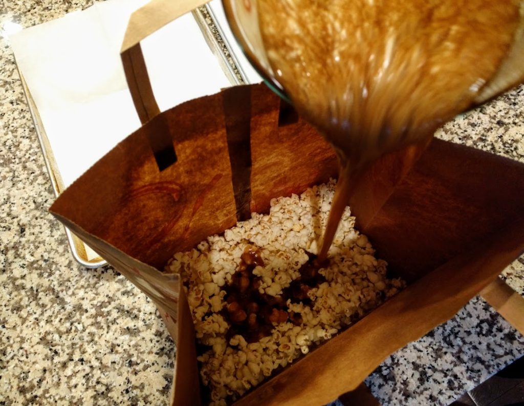 pouring brown sugar over bag of popcorn