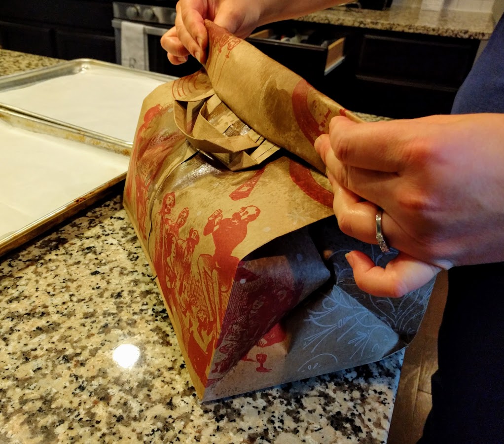 hands holding a folded grocery bag filled with popcorn