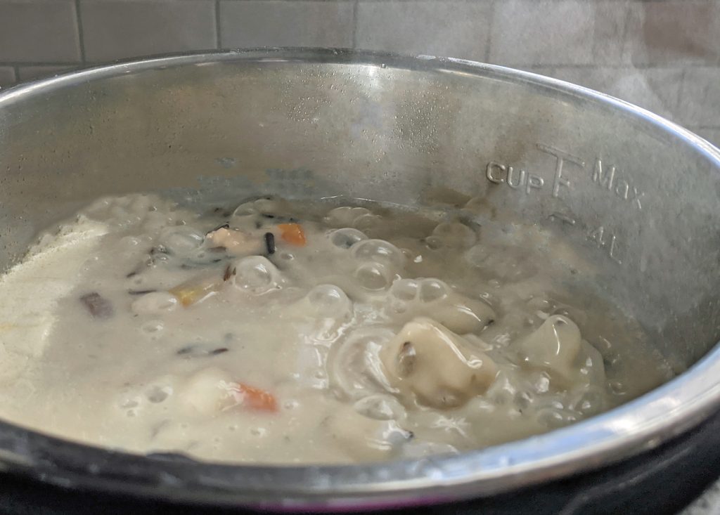 creamy chicken wild rice soup bubbling in an instant pot