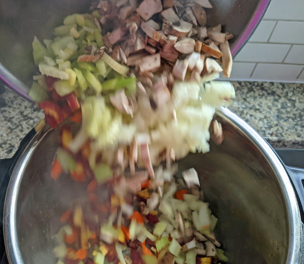 bowl of chopped vegetable being pouring into the instant pot
